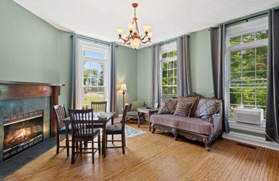 Historic charm meets modern comfort in this inviting living room, complete with a fireplace, cozy seating, and room to gather.