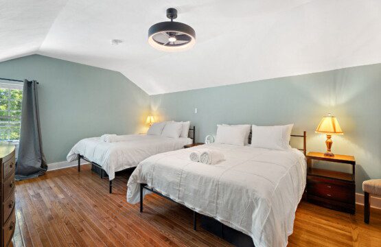 Perfect for families or groups, this spacious bedroom features two comfortable queen beds and plenty of room to relax.