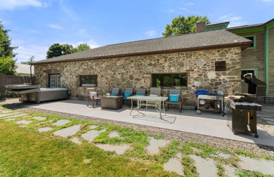 The spacious backyard patio is designed for outdoor living with comfortable seating, multiple grills, and plenty of room to gather.